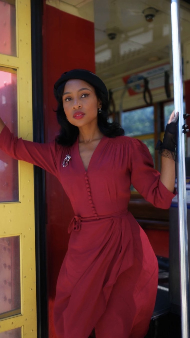 Red 1940s-style dress on a vintage streetcar